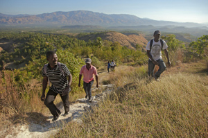 Hillside with trees and two volunteers in Haiti